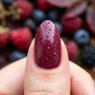 Extreme macro close-up of a single nail in Berry Compote color with dew droplets