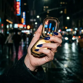 Almond nails in deep indigo night blue holding a glowing compact mirror