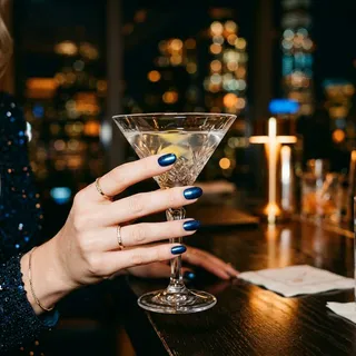 Metallic midnight blue round nails holding an elegant crystal martini glass